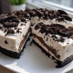 A rich, creamy, no-bake Oreo pie with a thick dark crust, topped generously with crushed Oreos and whole cookies.