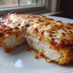 Cross-section view showing the juicy white meat of Easy Chicken Parmesan topped with melted cheese and marinara sauce.