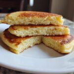 Close-up of fluffy almond flour pancakes stacked and cut to show the light, airy texture inside.