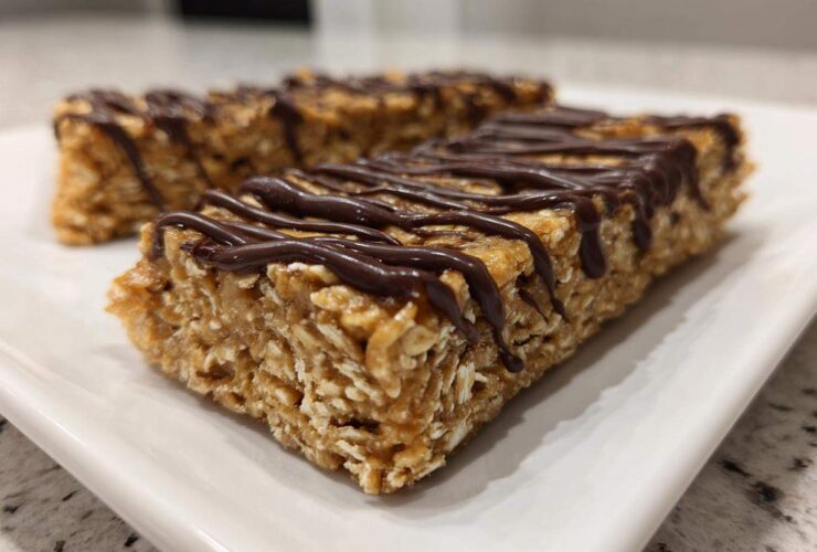 Close-up of homemade protein bars made with oats, drizzled generously with dark chocolate.