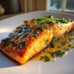 Close-up of a perfectly cooked honey garlic salmon fillet, glazed and topped with fresh chopped parsley.