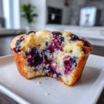 Close-up of a moist blueberry protein muffins cut in half, showing the dense, berry-filled interior.
