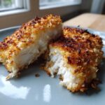 Close-up of juicy parmesan crusted chicken cut in half, showing the white interior.