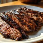 Close-up of perfectly grilled and sliced steak, showing juicy medium-rare interior from the carne asada marinade.