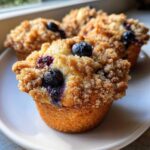 Close-up of delicious blueberry muffins topped with a generous brown sugar crumb topping.