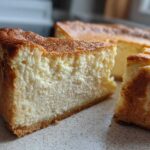 Close-up of a thick slice of baked Protein Cheesecake showing its creamy texture and golden-brown crust.