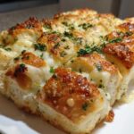 Close-up of cheesy hawaiian roll garlic bread, baked golden brown and topped with parsley.