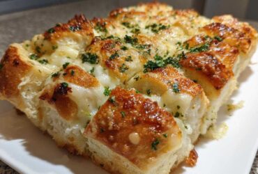 Close-up of cheesy hawaiian roll garlic bread, baked golden brown and topped with parsley.