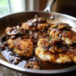 Four golden-brown chicken cutlets smothered in rich mushroom sauce, ready to serve as Chicken Marsala.