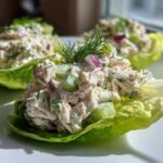 Three servings of creamy cottage cheese chicken salad served in crisp lettuce cups, garnished with dill.