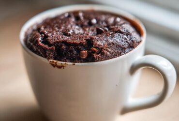 A rich, dark chocolate Cottage Cheese Microwave Brownie baked perfectly inside a white ceramic mug.