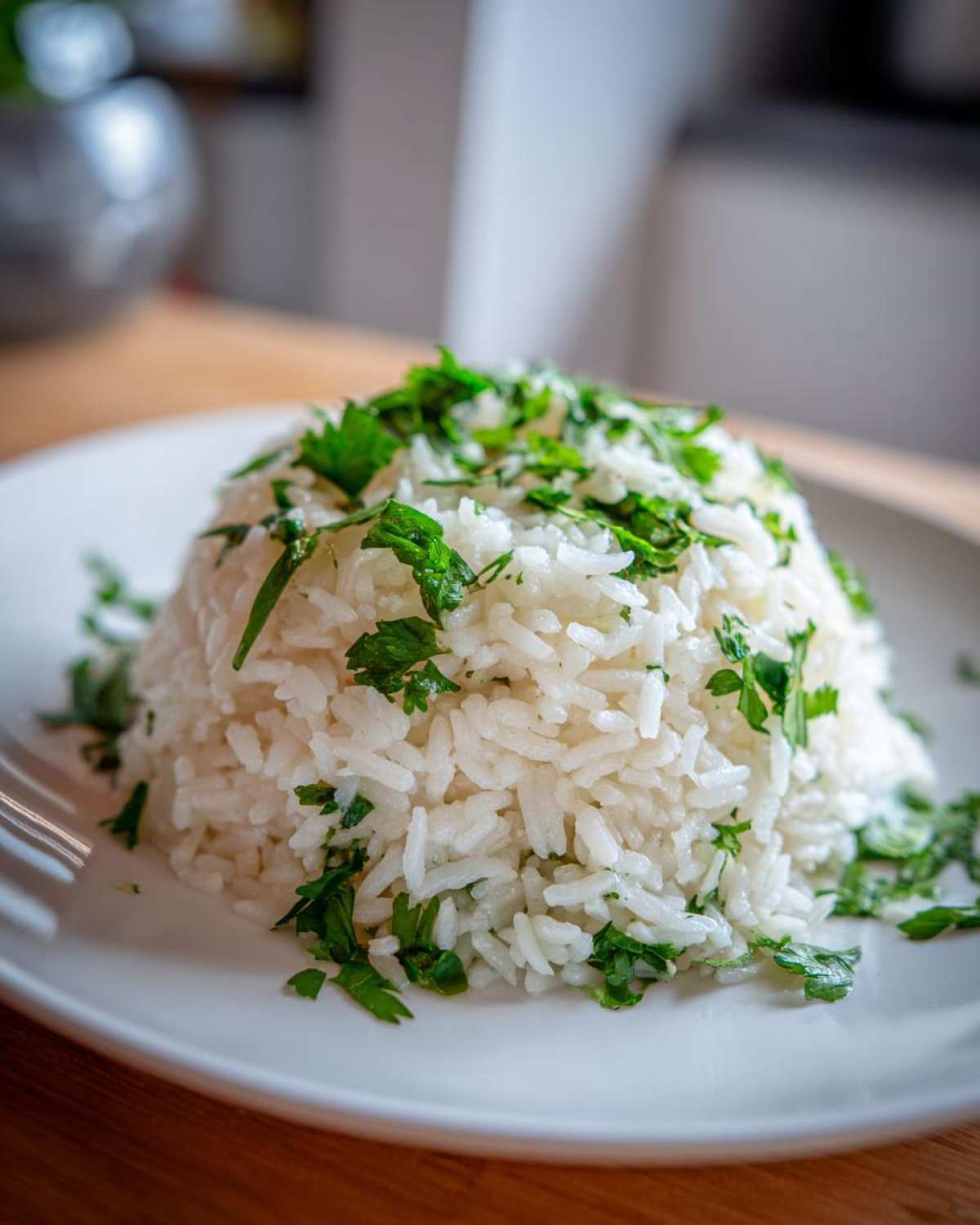 A mound of fluffy white rice seasoned with garlic butter and topped generously with fresh chopped parsley.