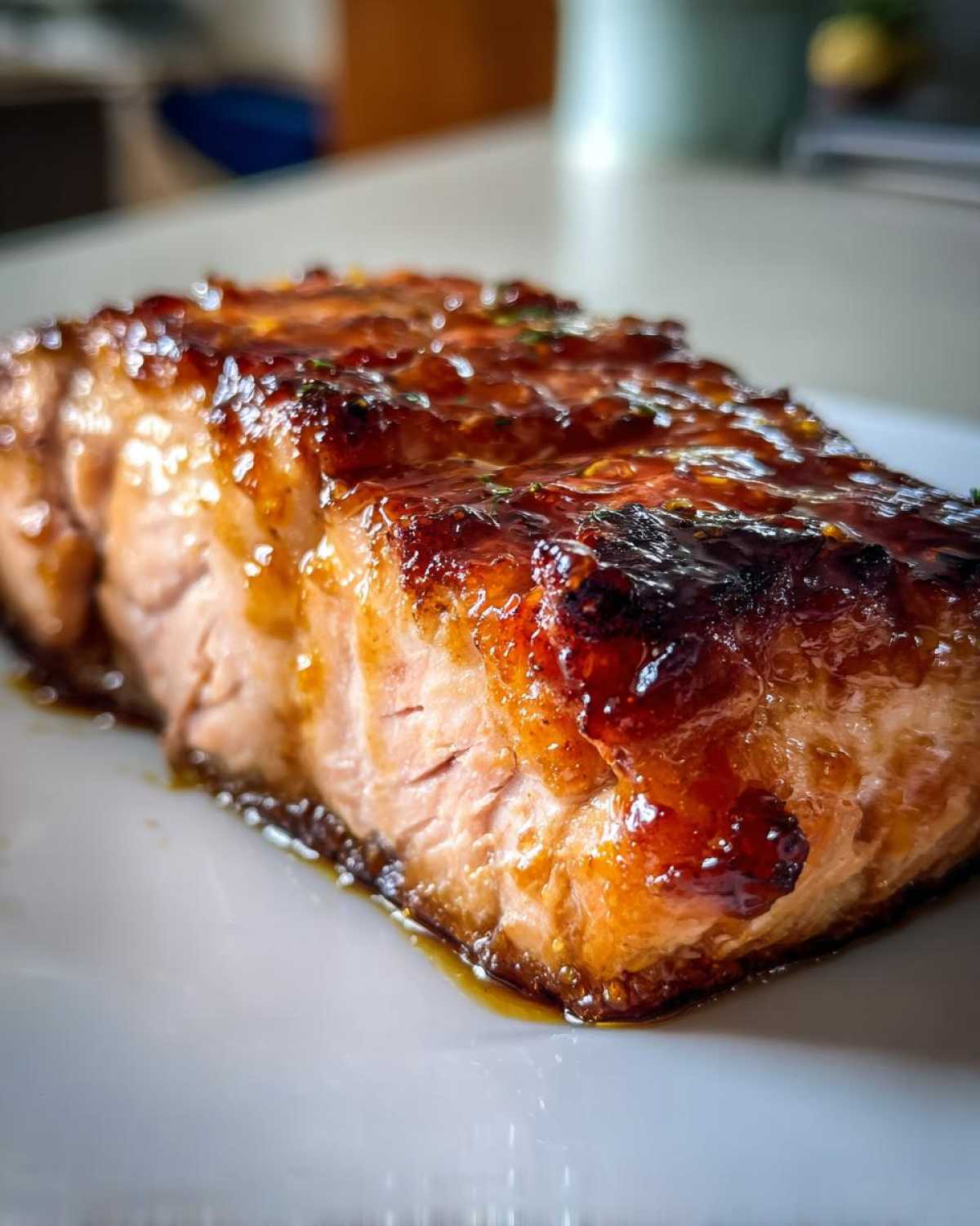 Close-up of a perfectly cooked, glazed salmon fillet with a shiny, caramelized top layer.