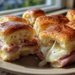 Close-up of gooey Ham and Cheese Sliders showing melted cheese stretching between the halves.