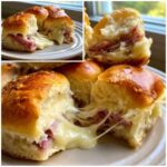 Close-up of freshly baked Ham and Cheese Sliders pulled apart showing melted, stringy cheese and ham inside soft rolls.