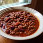 Close-up of a rich, meaty bowl of chili with red kidney beans, part of the best chili recipe.