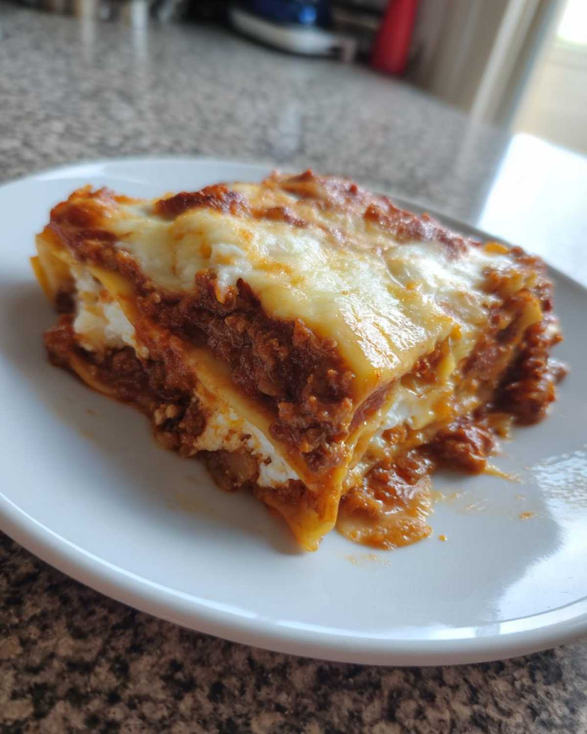 A close-up of a hearty slice of Lasagna with Cottage Cheese, showing layers of pasta, meat sauce, and melted cheese topping.