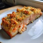 Close-up of a perfectly baked slice of stuffed salmon with a golden, crispy breadcrumb topping.