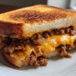 A close-up of a delicious texas toast sloppy joes sandwich filled with savory meat and melted cheddar cheese.