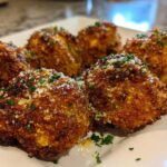 Close-up of golden brown, crispy Air Fryer Crispy Garlic Parmesan Mushrooms sprinkled with grated cheese and parsley.