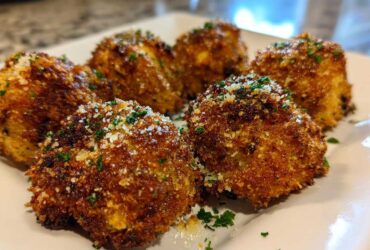 Close-up of golden brown, crispy Air Fryer Crispy Garlic Parmesan Mushrooms sprinkled with grated cheese and parsley.