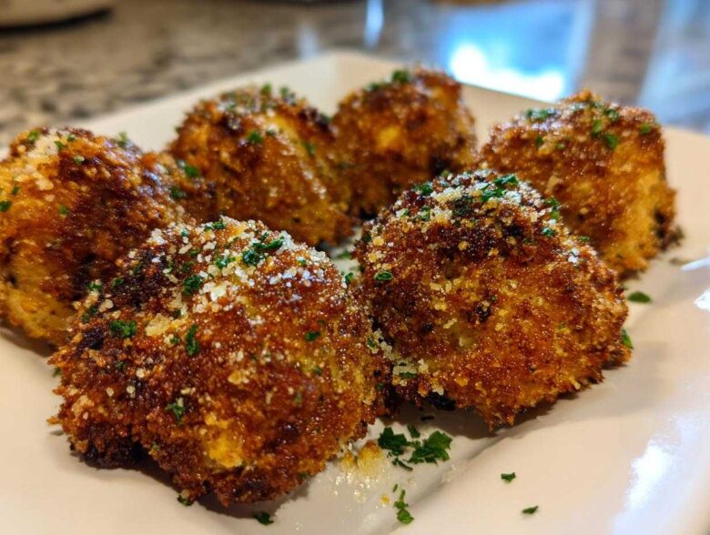 Close-up of golden brown, crispy Air Fryer Crispy Garlic Parmesan Mushrooms sprinkled with grated cheese and parsley.