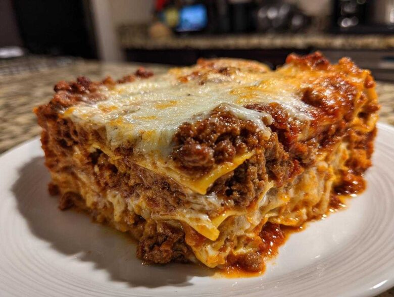 A thick, layered slice of baked lasagna with rich meat sauce and melted cheese topping.