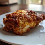 A close-up of a perfectly cooked piece of Baked Ranch Chicken Thighs with a crispy, seasoned crust.