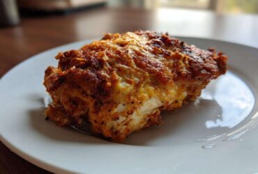 A close-up of a perfectly cooked piece of Baked Ranch Chicken Thighs with a crispy, seasoned crust.