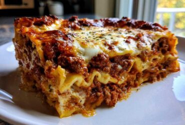 A thick, layered slice of Beef Lasagna with Ricotta and Mozzarella showing rich meat sauce and browned cheese topping.