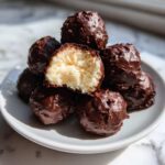 A stack of rich Chocolate Chip Cookie Dough Truffles NoBake, one cut open to show the creamy interior.