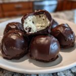 A stack of rich Chocolate Chip Cookie Dough Truffles NoBake, one cut open showing the doughy center.