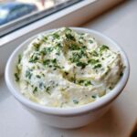 Close-up of rich Copycat Pizza Garlic Parmesan Dip Sauce topped generously with fresh chopped parsley.