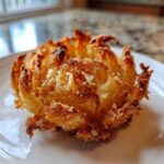 Close-up of a perfectly golden brown Crispy Mini Blooming Onion in Air Fryer served on a white plate.