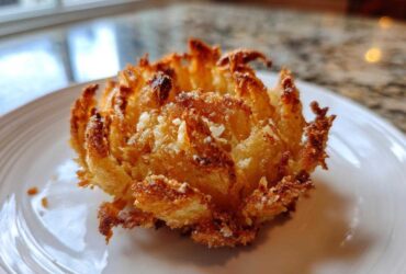 Close-up of a perfectly golden brown Crispy Mini Blooming Onion in Air Fryer served on a white plate.