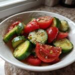 Close-up of a fresh Cucumber Tomato Salad Low Carb, featuring sliced cucumbers and cherry tomatoes tossed in a light vinaigrette.