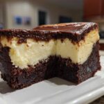 Close-up of a rich slice of Decadent Brownie Bottom Cheesecake showing the thick brownie base and creamy cheesecake layer.