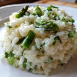Close-up of a perfectly portioned mound of Easy Creamy Asparagus Risotto with bright green asparagus pieces.