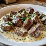 Close-up of Easy One-Pan Creamy Garlic Steak Bites served in a white bowl with rich garlic cream sauce and parsley.
