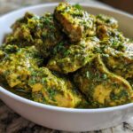 Close-up of tender chicken pieces coated in a vibrant green, creamy salsa verde sauce, ready to serve.