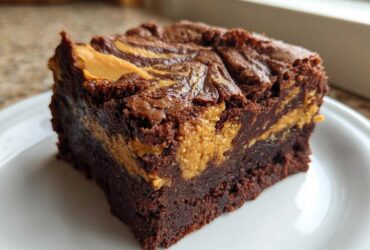 Close-up of a fudgy Gluten-Free Chocolate Peanut Butter Swirl Brownies square on a white plate.