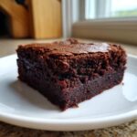 Close-up of a rich, fudgy Greek Yogurt Brownies Under 100 Calories on a white plate.