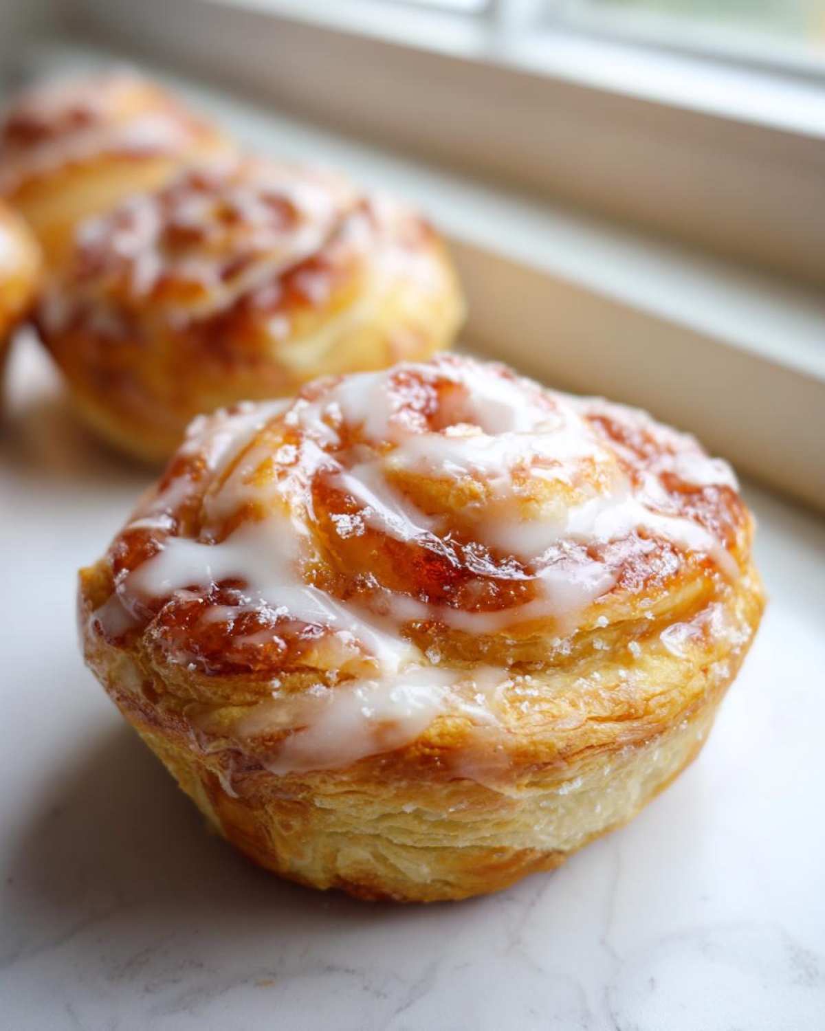 Close-up of a freshly baked Gluten-Free Strawberry Cream Cheese Danish with white icing drizzle.