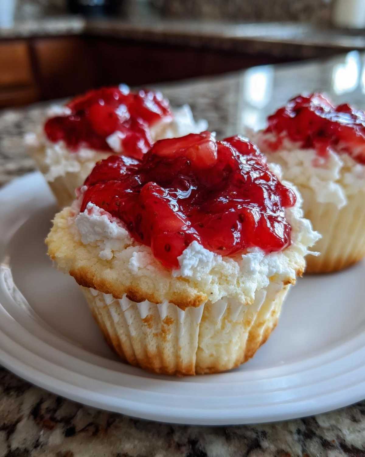 Close-up of a Gluten-Free Lemon Strawberry Angel Food Cup topped with whipped cream and strawberry compote.