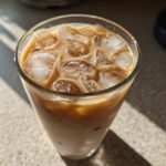 Close-up of a refreshing Iced Honey Vanilla Latte with Oat Milk filled with ice cubes.