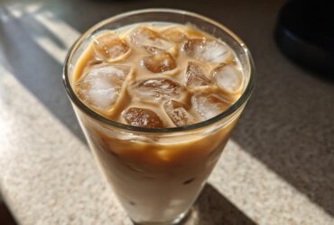 Close-up of a refreshing Iced Honey Vanilla Latte with Oat Milk filled with ice cubes.