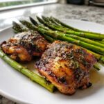 Two perfectly cooked, glazed chicken thighs served with bright green asparagus, ideal for a Keto Air Fryer for Busy Nights Quick Low Carb Dinner.