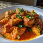 Close-up of rich, orange Keto Creamy Butter Chicken Skillet garnished with fresh cilantro.