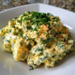 A generous serving of Keto Creamy Herb Deviled Egg Salad topped with fresh chives and paprika.