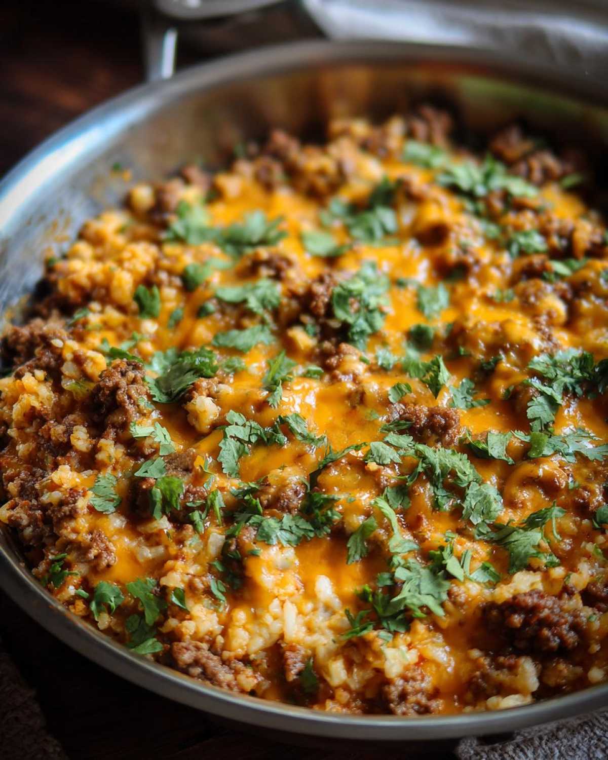 Close-up of Keto Creamy Taco Skillet with cauliflower rice, seasoned ground beef, melted cheddar cheese, and fresh cilantro.